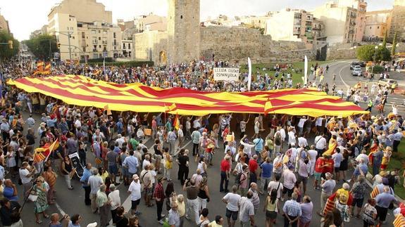 Cientos de manifestantes portan una gran senyera.