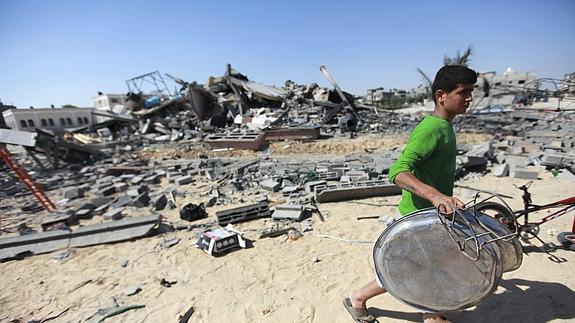 Un joven recoge chatarra en los escombros en Gaza 