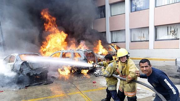 Los bomberos tratan de sofocar el fuego iniciado por los manifestantes en Chilpancingo 