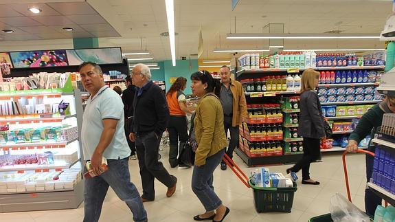 Personas haciendo la compra en un supermercado. 