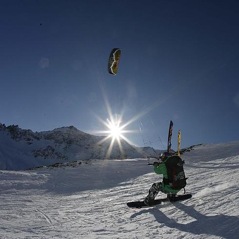 Un snowboarder practicando snowkite