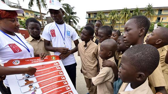 Voluntarios explican a los niños cúales son los síntomas del ébola.  