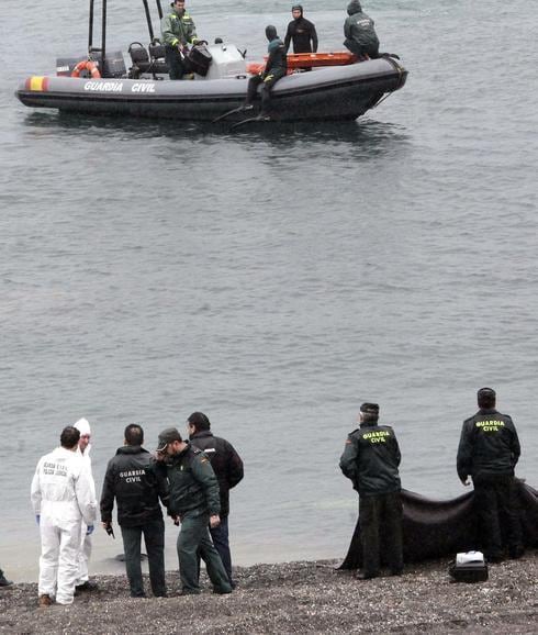 Agentes de la Guardia Civil custodian el cuerpo de uno de los inmigrantes fallecidos. 