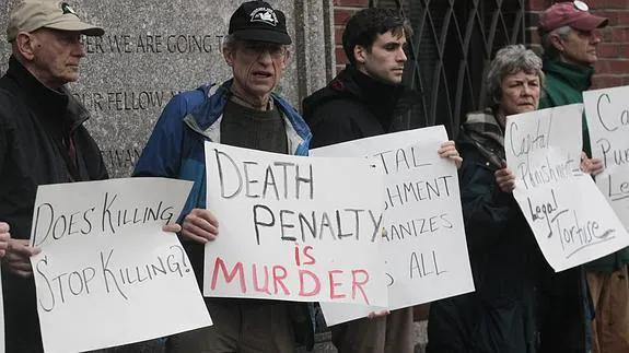 Varias personas protestan contra la pena de muerte frente a la corte federal. 