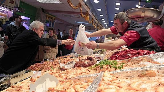 Un hombre compra en una pescadería. 