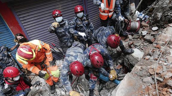 Miembros de los equipos de rescate buscan víctimas entre los escombros. 