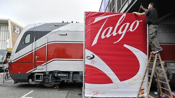 Un trabajador coloca un cartel de Talgo, en los preparativos de la Feria de Innotrans, en Berlín.