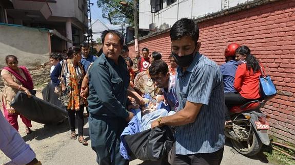 Pacientes nepalíes son sacados del hospital en Katmandú tras el seísmo.