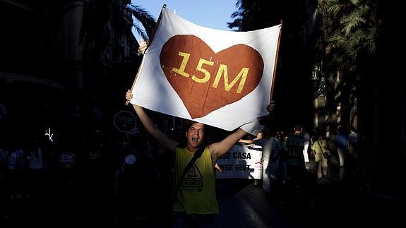 Un joven con un cartel del 15M. 