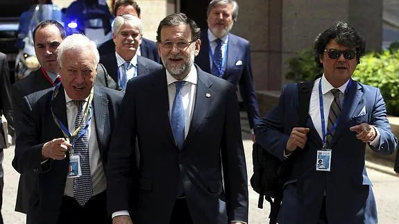 El presidente del Gobierno, Mariano Rajoy (c), acompañado de su jefe de gabinete, Jorge Moragas (d), y el ministro de Asuntos Exteriores, José Manuel García-Margallo (i), a su llegada a la Cumbe de la UE-Cela.