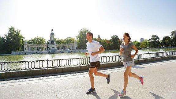 Una pareja corre por el madrileño parque de El Retiro.