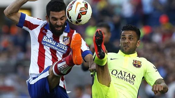 Arda Turan pugna con Dani Alves en un Atlético-Barça