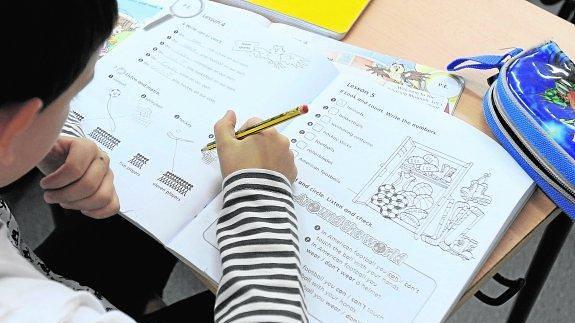 Un estudiante realiza los ejercicios de su cuaderno en clase.