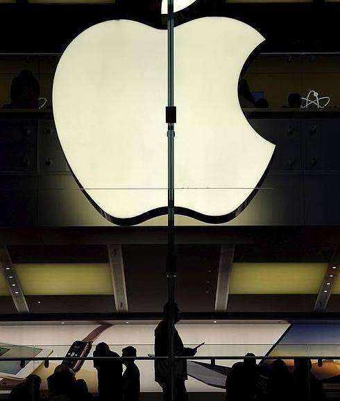 Vista de las siluetas de varios clientes en una tienda de la firma Apple en Sídney, Australia.