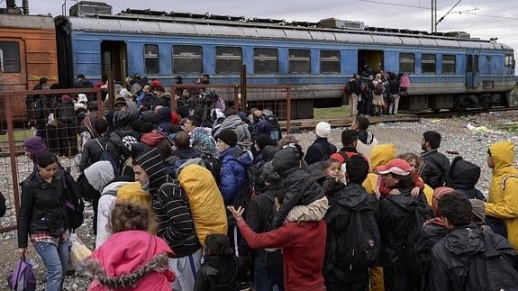 Varios refugiados se agolpan para subir a un tren antes de partir hacia a la frontera serbia. 