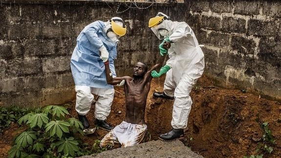 Trabajadores del centro de tratamiento del Ébola de Hastings trasladan a un hombre enfermo, en Sierra Leona. 