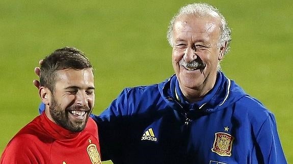 Del Bosque (d) bromea con Jordi Alba. 