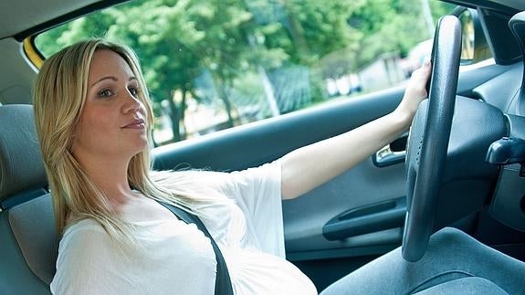 Una mujer conduce un coche. 