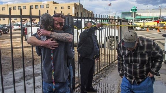 Dos hombres se abrazan tras el tiroteo. 