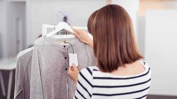 Una mujer observa la etiqueta de una prenda.