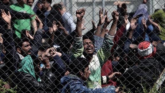 Refugiados afganos y pakistaníes protestan en un centro de detención en la isla griega de Lesbos. 