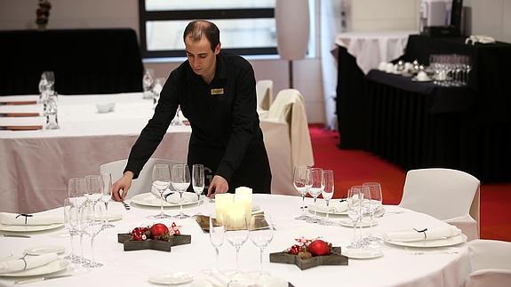 Camarero prepara las mesas de un restaurante. 