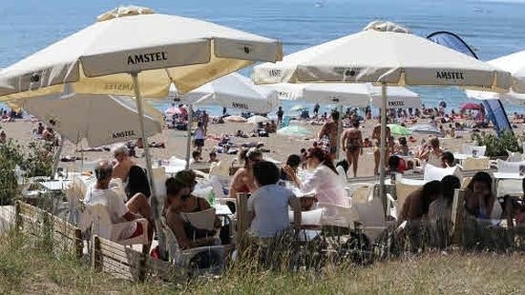 Turistas en un chiringuito en la playa. 