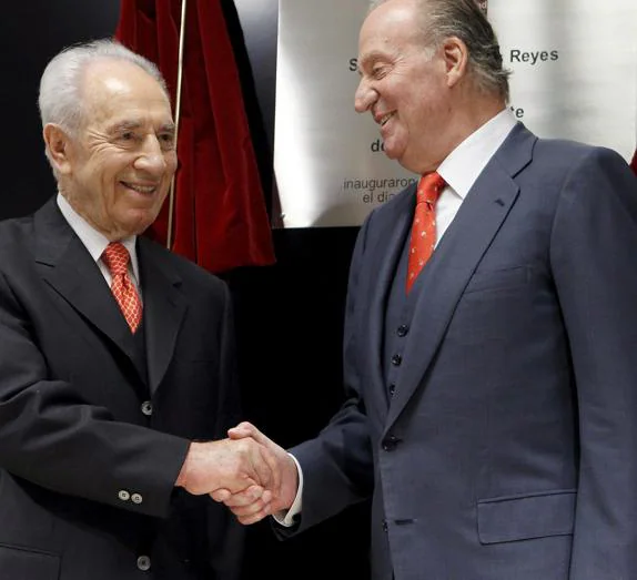 El rey Juan Carlos estrecha la mano del ex presidente israelí, Simon Peres (i) en una imagen de archivo.