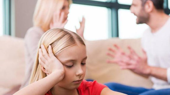 Una niña, junto a sus padres discutiendo.