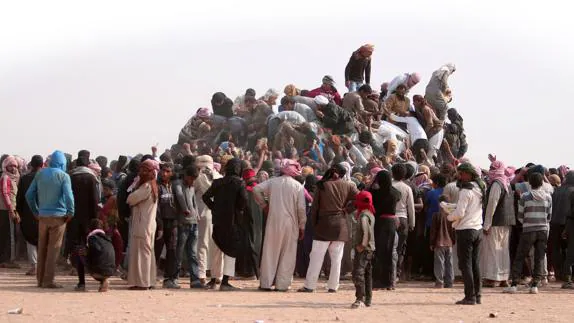 Los refugiados que huyen del Daesh tratan de conseguir alimentos en la frontera iraquí.