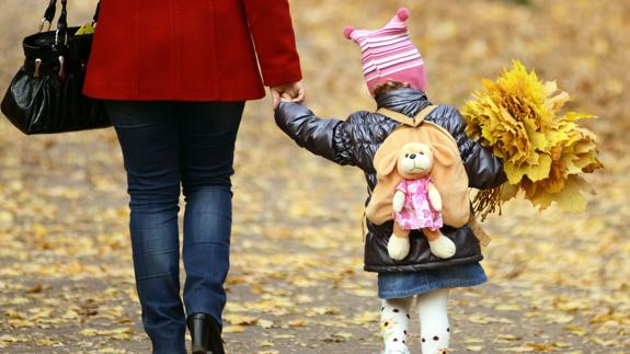 Madre e hija pasean de la mano.