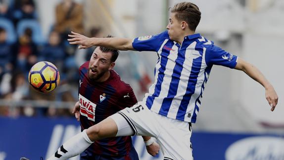 El delantero del Eibar, Sergi Enrich (i), y el centrocampista del Alavés, Marcos Llorente (d), luchan por el balón.