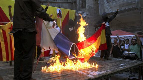 Manifestantes queman una bandera de España y otra de Francia durante la Diada.