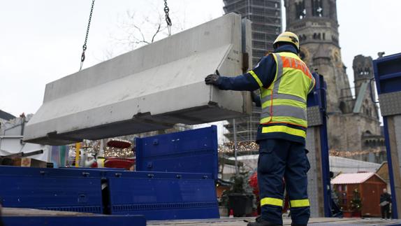 Trabajadores colocan barreras alrededor de un mercadillo navideño en la plaza Breitscheid de Berlín.