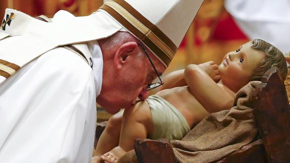 El papa Francisco besa una estatua de Jesús recién nacido.
