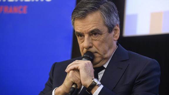 Fillon, candidato conservador, se agarra al micrófono. 