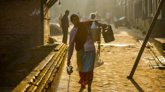 Una mujer nepalesa transporta agua.