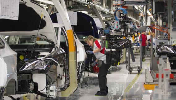 Operarios trabajando en una fábrica de automóviles. 