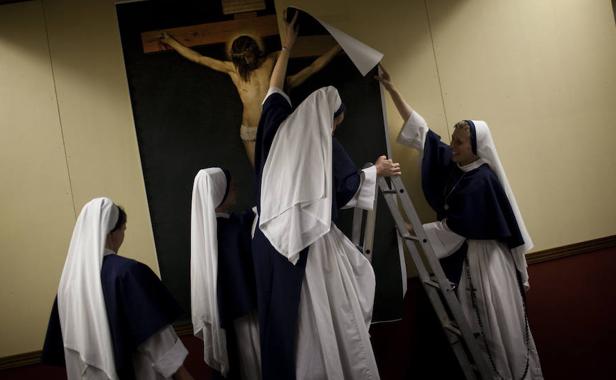 Varias monjas colocan un póster de Jesucristo. 