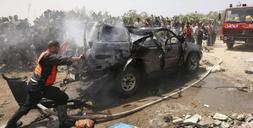 Un miembro de rescate examina los restos de un vehículo atacado por un misil israelí que mató a dos palestinos en Rafah. / E. BABA-REUTERS