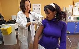 Una inmigrante recibe una vacuna. ::                         C.R.