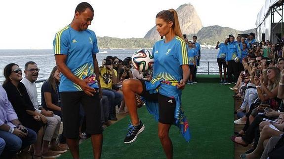 La presentadora Fernanda Lima (d) y el exfutbolista Cafu desfilan en el lanzamiento del uniforme de los voluntarios