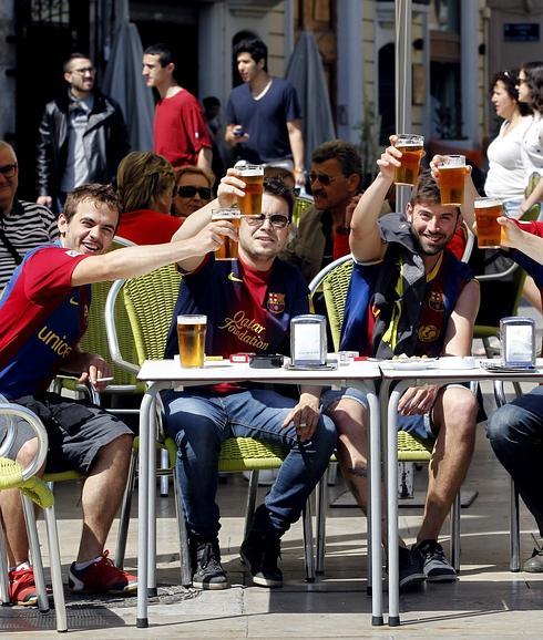 Aficionados del Barcelona toman una cerveza en una terraza del centro de Valencia.