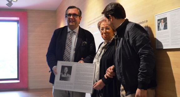Luis Martínez-Portillo entrega a Marisa Sánchez, acompañada de Paniego, el panel con su trayectoria que se colgará en el museo. 