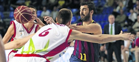 Juan Carlos Navarro lanza el pase a un compañero entre dos rivales. 