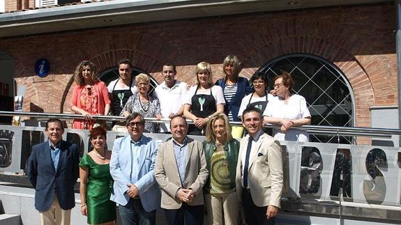 Autoridades políticas y algunos de los propietarios de los establecimientos, en la fachada de la plaza de Abastos. 