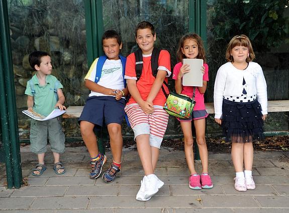 Álex, Adrián, Borja, Olivia y Melisa esperan en la parada del autobús de Sorzano antes de trasladarse a Nalda. 