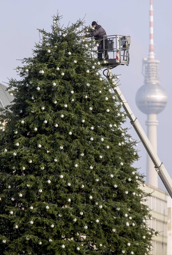 Un obrero decora un árbol navideño gigante en el centro de la capital alemana. 