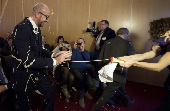 Una activista de Liliths rocía con mayonesa al primer ministro belga, al que la agresión parece divertir. 