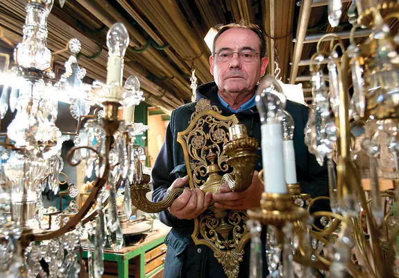 Enrique posa junto a dos lámparas antiguas, recién restauradas, en su taller de Juan Lobo. 